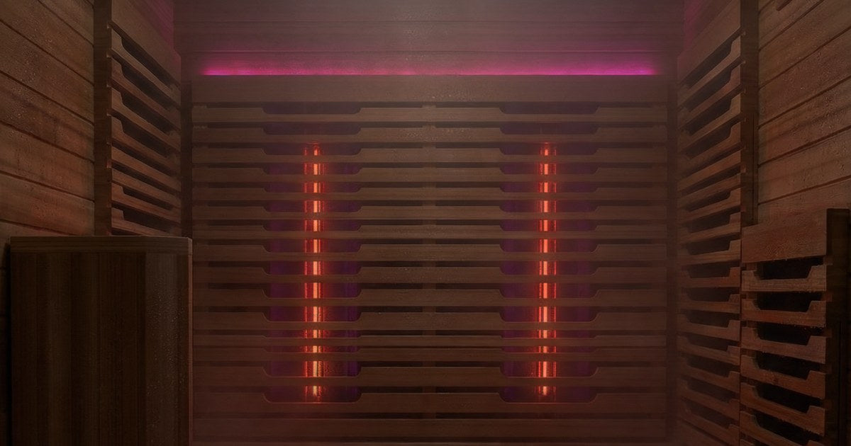 Sauna interior wall with infrared heaters glowing red under a pink light strip
