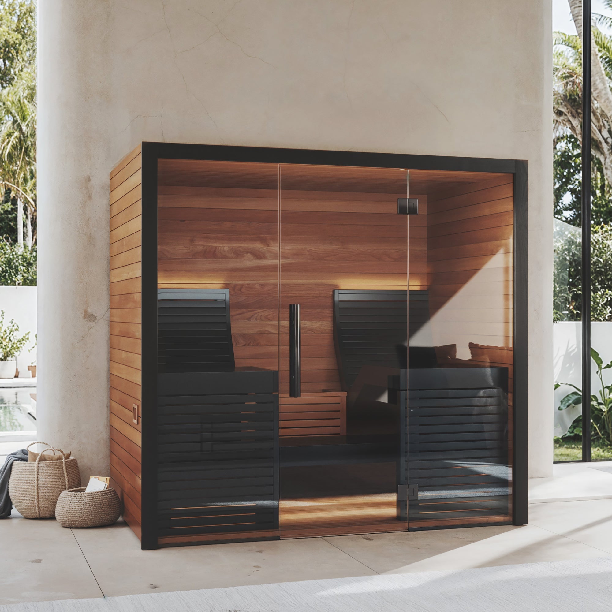 Wooden sauna interior with a glass door showing an outdoor garden view.